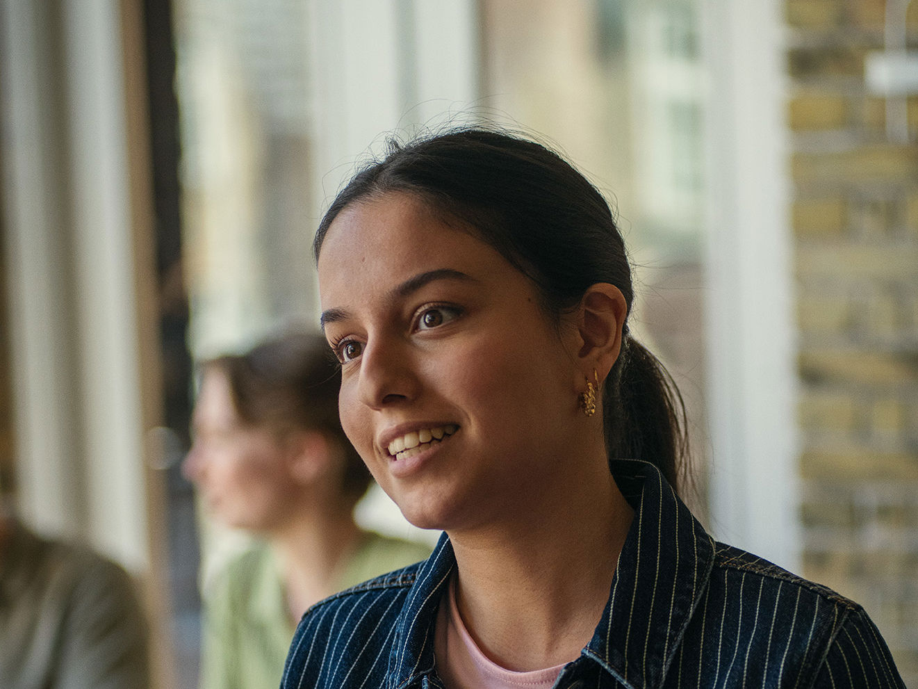Elev fra Det Internationale Gymnasium står med en bog