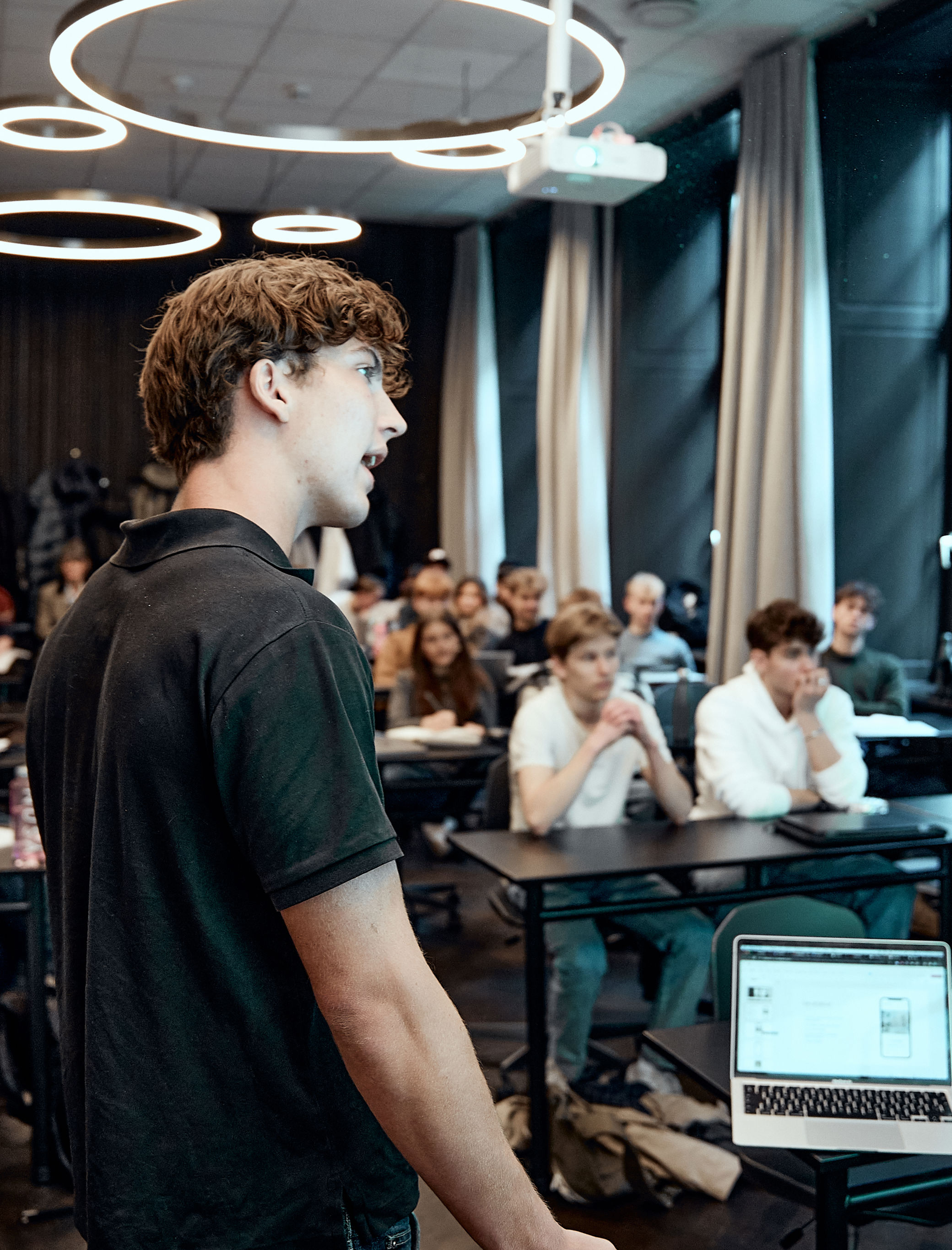 Elev fra Jesper Buchs Iværksætterakademi står og præsenter noget foran en klasse