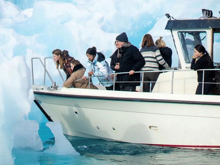 Elever og medarbejder på båd i havet ved Nuuk
