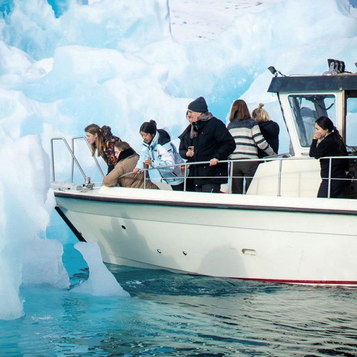 Elever og medarbejder på båd i havet ved Nuuk